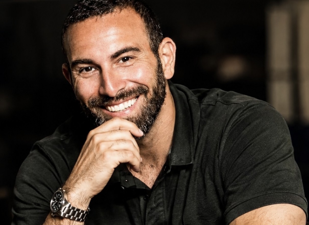Luciano Rubino in primo piano con la mano sotto il mento